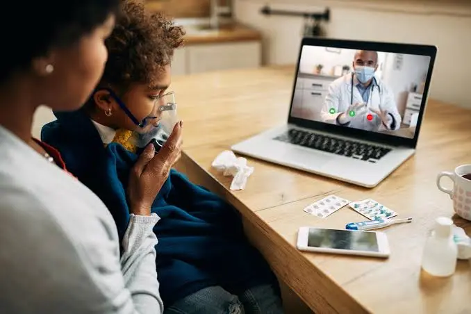 Médico emergencista utilizando estação de telemedicina para suporte com especialista em terapia intensiva pediátrica.